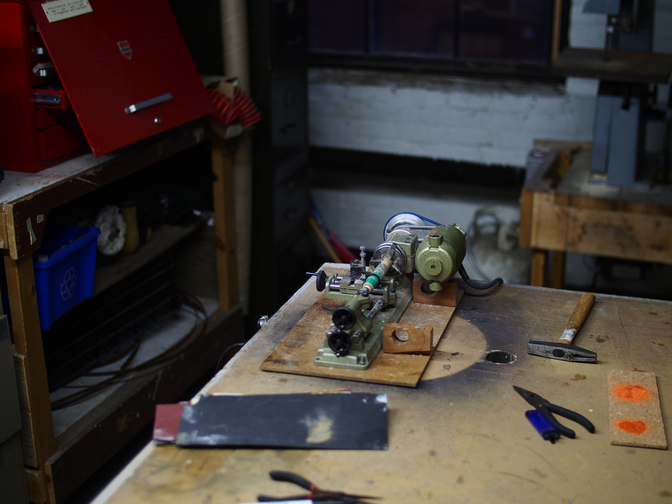 A wooden kitchen table dusted with flour, a rolling pin resting beside a bowl of dough, morning light from a window catching the particles suspended in the air