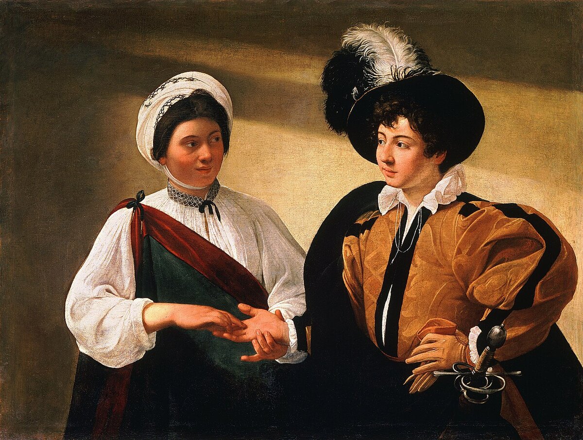 Caravaggio's painting 'The Fortune Teller': a smiling fortune-teller reads a young man's palm while quietly slipping the ring from his finger